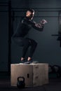 Strong man doing box jumps at the gym