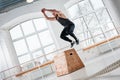 Strong man doing jump on wooden squat box at light hall Royalty Free Stock Photo