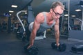 Strong man doing push-ups exercises on dumbbells Royalty Free Stock Photo