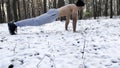 Strong man doing push ups on snow at winter forest. Sportsman exercising at nature. Young guy training outdoor. Muscular Royalty Free Stock Photo