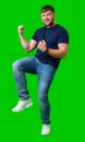 A strong man with fists raised, smiling confidently, on a bright green background Royalty Free Stock Photo