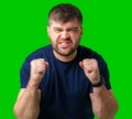 A strong man with fists raised, smiling confidently, on a bright green background Royalty Free Stock Photo