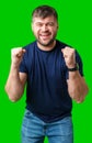 A strong man with fists raised, smiling confidently, on a bright green background Royalty Free Stock Photo