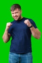 A strong man with fists raised, smiling confidently, on a bright green background Royalty Free Stock Photo