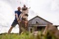 Strong man lumberjack choping wood for the winter, with a large steel ax, in the village, against the background of an Royalty Free Stock Photo