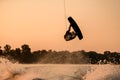 strong man making trick in jump time with wakeboard on sunset sky background. Royalty Free Stock Photo