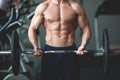 Strong man with muscular body working out in gym. Weight exercise with barbell in fitness club. Toned image Royalty Free Stock Photo