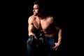 Strong man with muscular body working out. Weight exercise with dumbbell on black background. Royalty Free Stock Photo