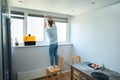 Strong man repairing a window with a screwdriver Royalty Free Stock Photo