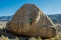 Man Rock Climbing a Large Boulder with Mountains in Background Royalty Free Stock Photo