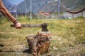 A strong man`s hand with an axe chopping wood at a camping in a mountainous region of Georgia. Royalty Free Stock Photo