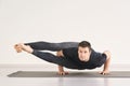 Strong man stand at Astavakrasana. Fitness yoga exercise. Royalty Free Stock Photo