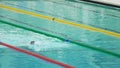 Strong man swimming front crawl in pool, slow motion. Perseverance, fortitude