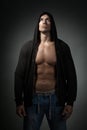 Strong man wearing black hoodie isolated on dark Royalty Free Stock Photo