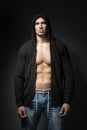 Strong man wearing black hoodie isolated on dark Royalty Free Stock Photo