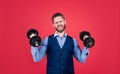 Strong manager in formal style lifting heavy dumbbells red background, strength Royalty Free Stock Photo