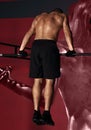 Strong masculine man athlete doing pull ups o dark fitness club background. Closeup portrait Royalty Free Stock Photo