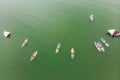 Strong men floating on a SUP boards in a beautiful bay on a sunny day. Aerial view of the men crosses the bay using the Royalty Free Stock Photo