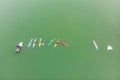 Strong men floating on a SUP boards in a beautiful bay on a sunny day. Aerial view of the men crosses the bay using the Royalty Free Stock Photo