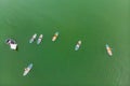 Strong men floating on a SUP boards in a beautiful bay on a sunny day. Aerial view of the men crosses the bay using the Royalty Free Stock Photo