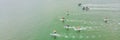 Strong men floating on a SUP boards in a beautiful bay on a sunny day. Aerial view of the men crosses the bay using the Royalty Free Stock Photo