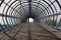 Metal tunnel bridge with wooden walkway Royalty Free Stock Photo