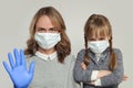 Strong mother and daughter wearing medical protective face mask on white, Covid-19 safety concept