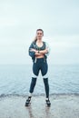 Strong and motivated. Confident disabled woman in sports clothing with prosthetic leg standing with crossed arms in Royalty Free Stock Photo
