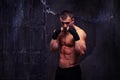 Strong Muscular Bodybuilder Standing In Boxing Pose Against Black Wretched Background