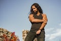 Strong muscular handsome man at blue summer sky background. Fashionable man with long wavy hair and strong healthy body