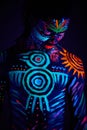 Strong muscular male covered with fluorescent luminescence body art