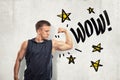 Strong muscular young man showing biceps with WOW sign and yellows stars drawn on white wall background