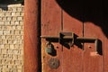 Strong old secured metal lock on traditional ancient wooden door of old Korean stone wall in the afternoon Royalty Free Stock Photo