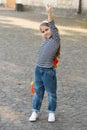 Strong performance. Proud skater hold up hand with clenched fist. Small girl with penny board outdoors. Power slide Royalty Free Stock Photo