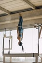 Strong pilates instructor doing a straight pose in a big Pilates Studio with wide windows