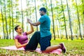 Strong and powerful afro american couple in love are working out abs exercises outside in park or forest