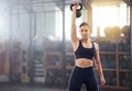 Strong, powerful woman doing kettlebell weight lift exercise, workout or training in wellness gym. Sports person holding