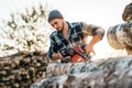 Strong professional lumberman use chainsaw on sawmill Royalty Free Stock Photo