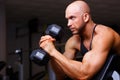 Strong ripped bald man with huge muscles pumping iron. Sports ma