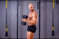 Strong ripped bald man pumping iron. Sports man working out with