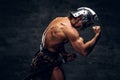 Strong shirtless gladiator in helmet is showing his muscules