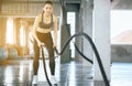 Strong and slim woman using battle rope at gym,Female doing exercise in functional training Royalty Free Stock Photo