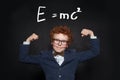 Strong and smart child student on blackboard with science formula