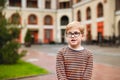Strong, smart and funny little boy playing outdoors, wearing eyeglasses