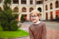 Strong, smart and funny little boy playing outdoors, wearing eyeglasses