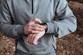 Strong smiling sportsman adjusting sport watch for an outdoor running training on a autumn day