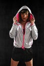 Strong sport freckles woman wearing training jacket hood on posing defiant