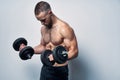 Strong sport sirtless man making weightlifting with dumbbells