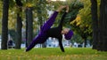 Strong sportive islamic girl in hijab yoga teacher woman stands in side plank on grass in park doing Ardhachandrasana