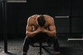 Strong sporty man sitting on gym bench suffering breakdown to overcome Royalty Free Stock Photo